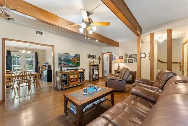 a living room with furniture a flat screen tv and a large window