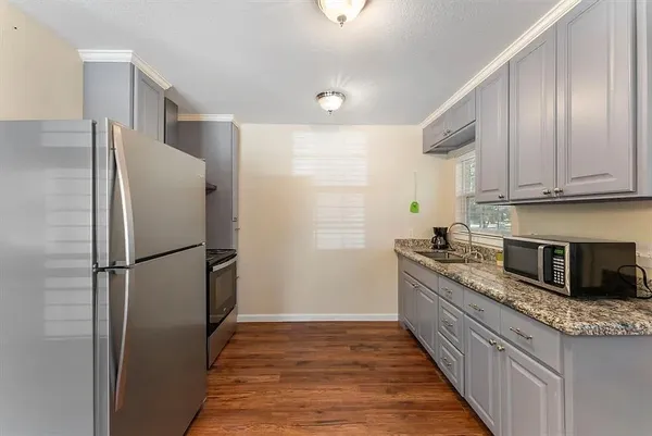 a kitchen with stainless steel appliances granite countertop a refrigerator a sink and a stove