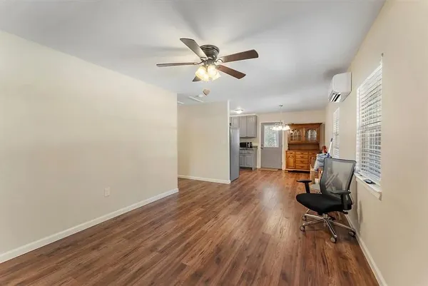 a view of a workspace with wooden floor and a ceiling fan