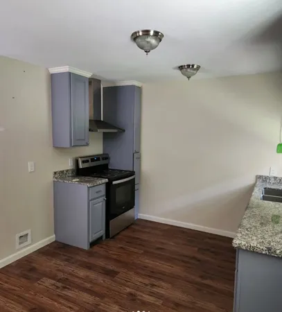 a kitchen with granite countertop a stove and a refrigerator