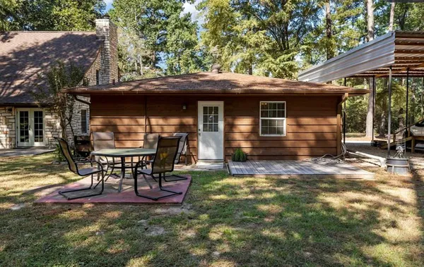 a view of a chair and table in backyard of the house