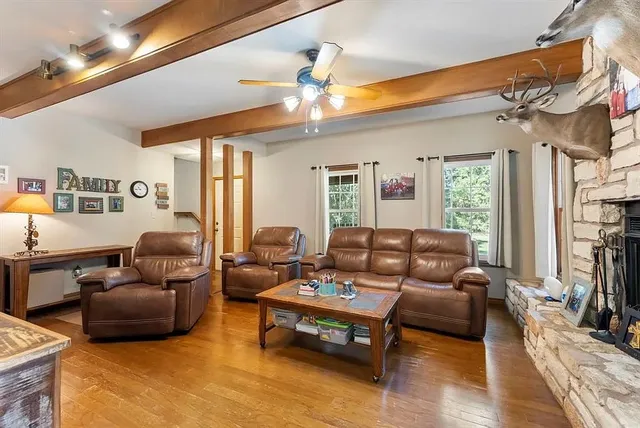 a living room with furniture a ceiling fan and a window