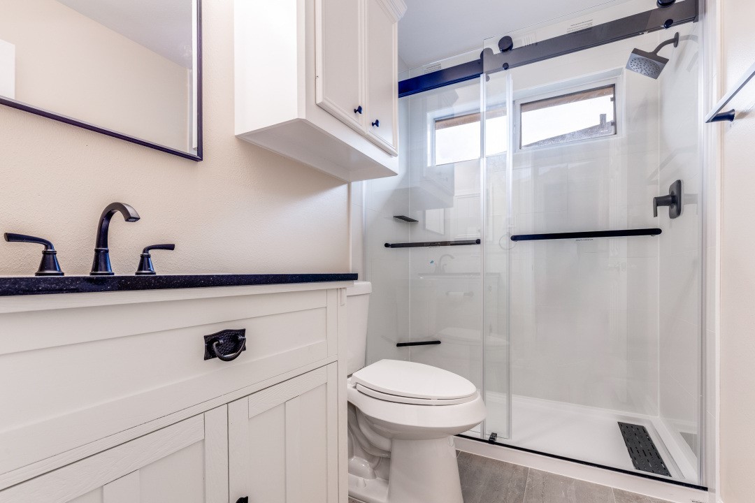 3231 Alabama Street Houston, TX 77004 - Photo 18 of 20 a bathroom with a sink a mirror and a shower