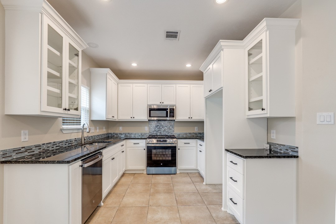 3231 Alabama Street Houston, TX 77004 - Photo 6 of 20 a kitchen with stainless steel appliances granite countertop a stove sink and cabinets