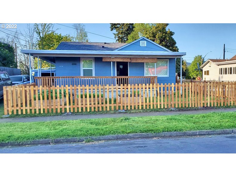 a view of a house with a small yard and wooden fence