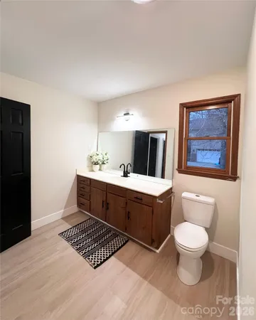a spacious bathroom with a toilet a sink and a mirror