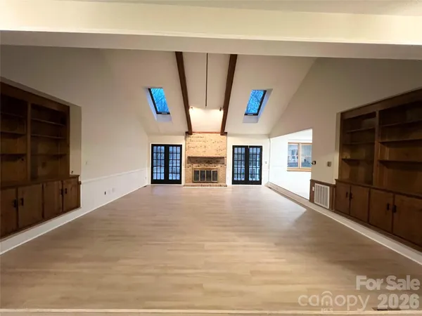 a view of an empty room with a fireplace and a window