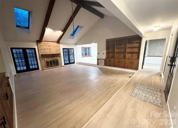 a view of an empty room with closet and fireplace
