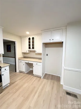 a kitchen with granite countertop a sink cabinets and wooden floor