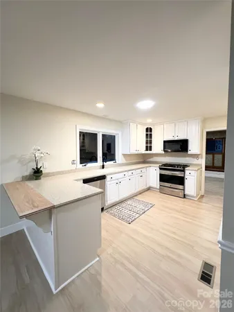 a large kitchen with a sink and stainless steel appliances