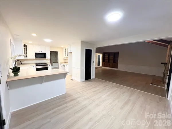a view of kitchen with wooden floor and electronic appliances
