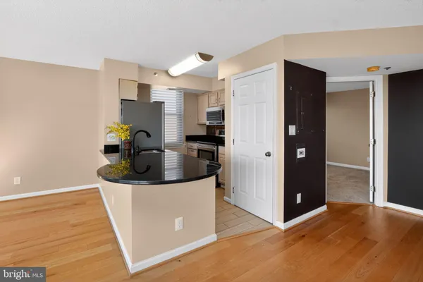 a living room with stainless steel appliances kitchen island granite countertop a refrigerator and a stove top oven