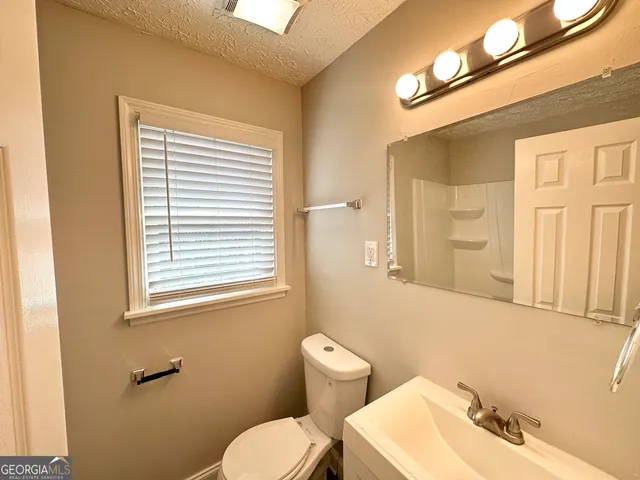 a bathroom with a toilet a sink and a mirror