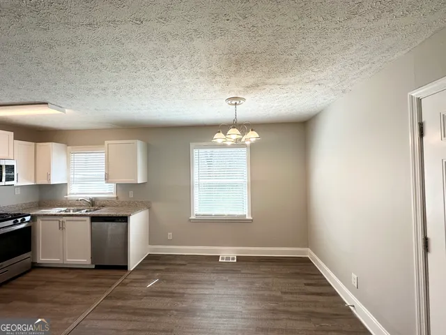 a view of a kitchen with a sink wooden floor and a window
