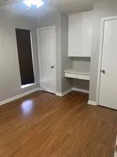a view of a room with wooden floor and fan