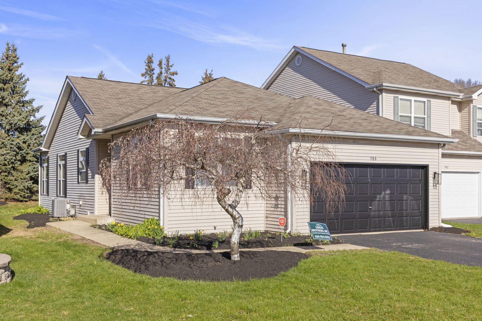 580 Chestnut Drive Oswego, IL 60543 - Photo 2 of 20 a front view of a house with a garden and plants