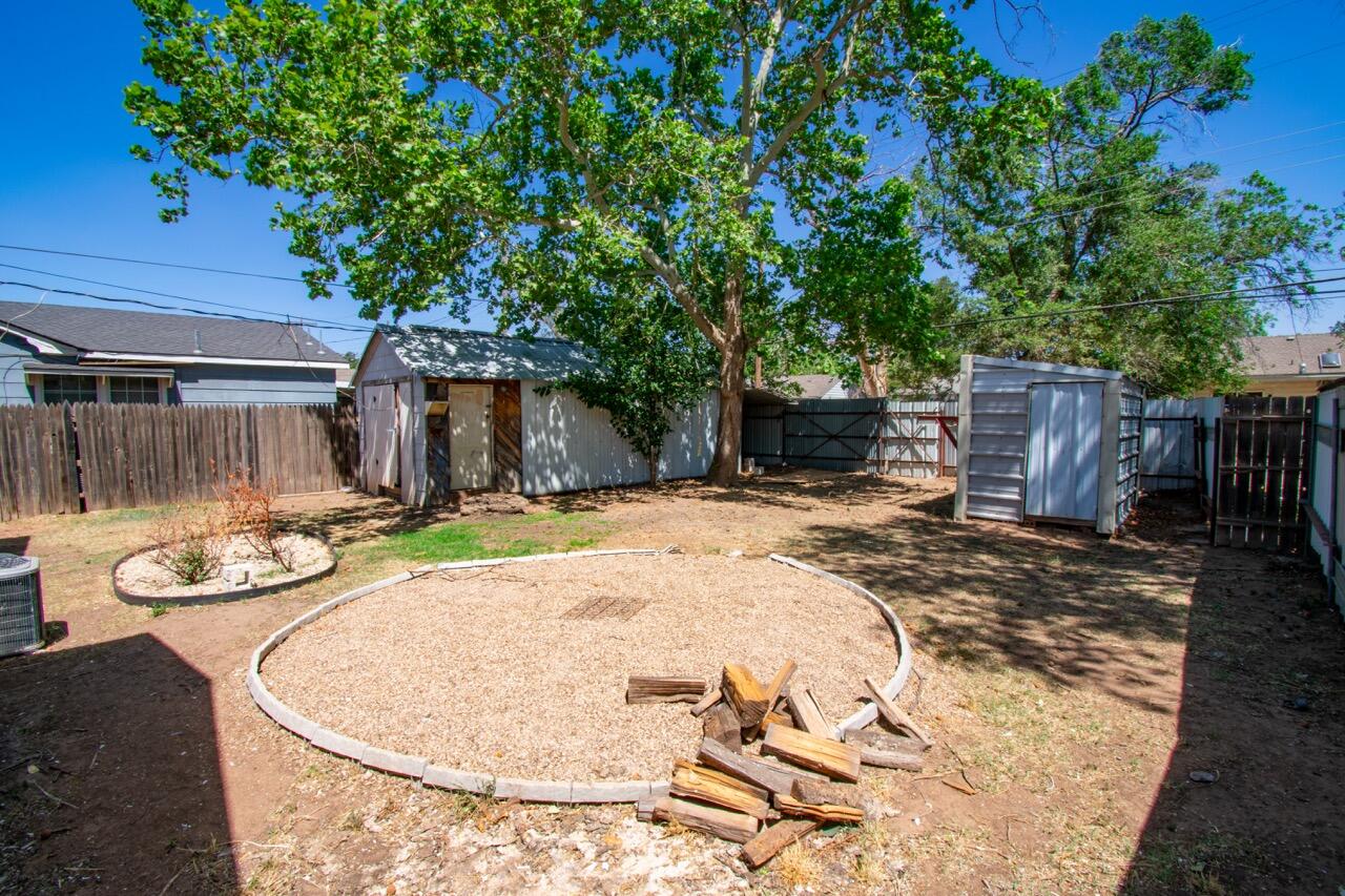 2424 27th Street Lubbock, TX 79411 - Photo 14 of 14 a view of a backyard with table and chairs with wooden fence and plants