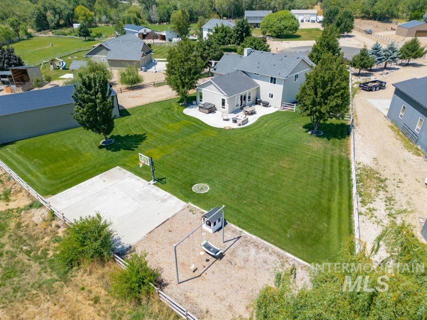 23800 Breyer Road Caldwell, ID 83607 - Photo 38 of 50 Expansive green lawn surrounds the property, featuring a concrete sports court with a basketball hoop