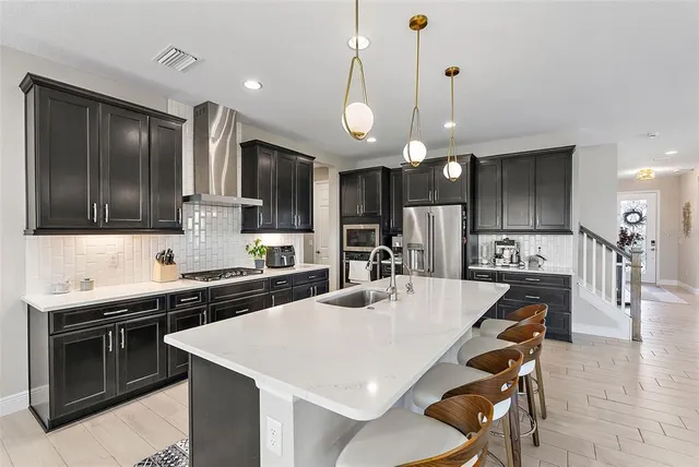 a kitchen with stainless steel appliances a stove a sink island and a refrigerator