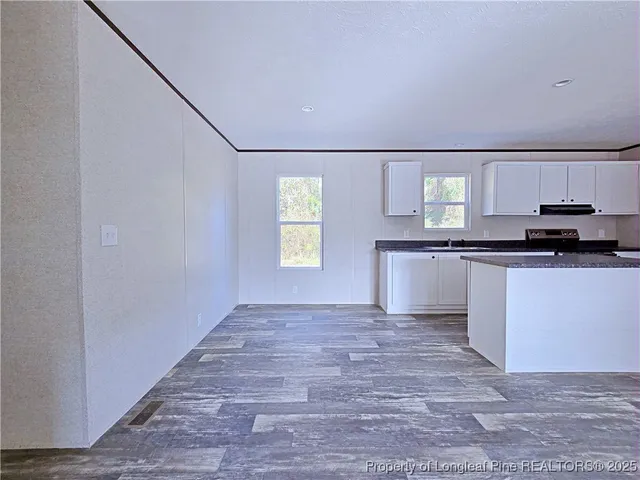 a view of a kitchen with microwave and window