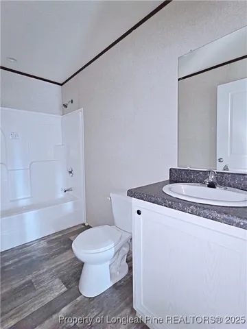 a bathroom with a granite countertop sink toilet a mirror and shower