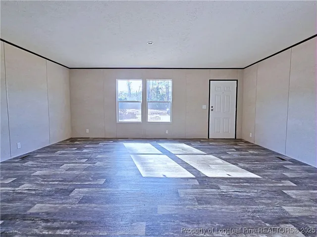 a view of an empty room with a window and closet