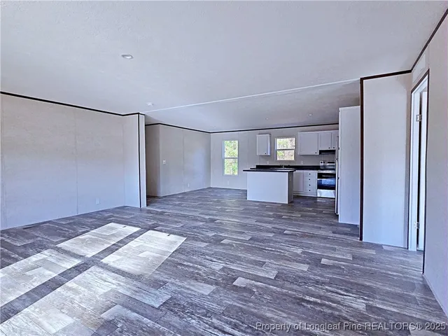 a view of a kitchen with wooden floor and a refrigerator