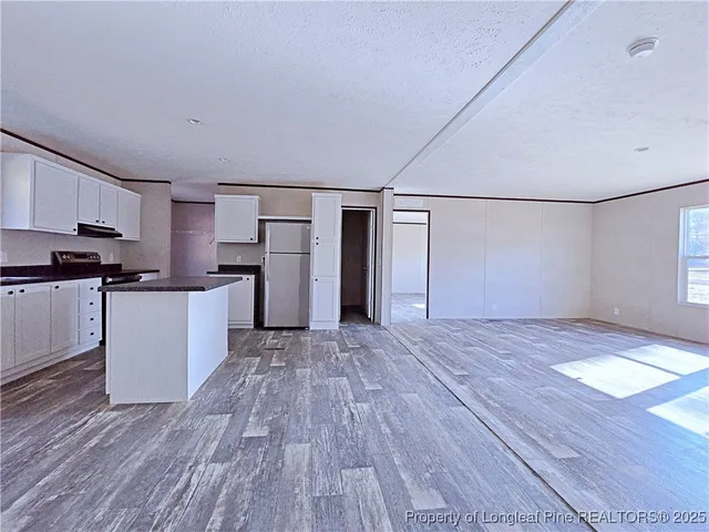 a view of kitchen with wooden floor and electronic appliances