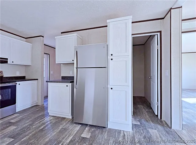 a view of a kitchen with a refrigerator and a stove top oven