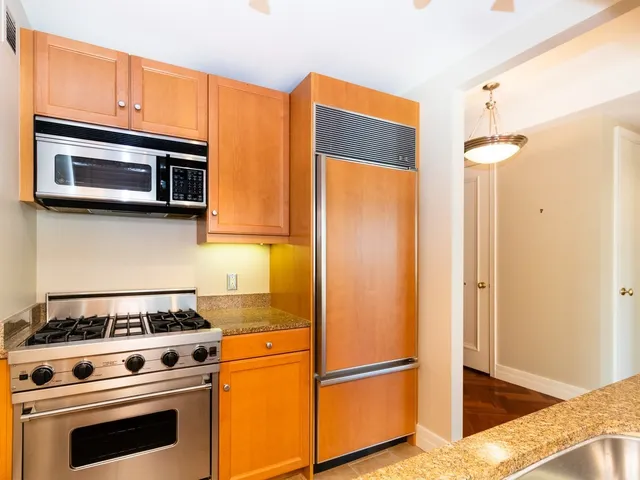 a kitchen with stainless steel appliances granite countertop a stove microwave and refrigerator