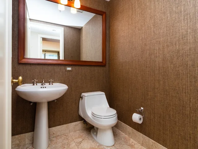a bathroom with a toilet a sink and mirror