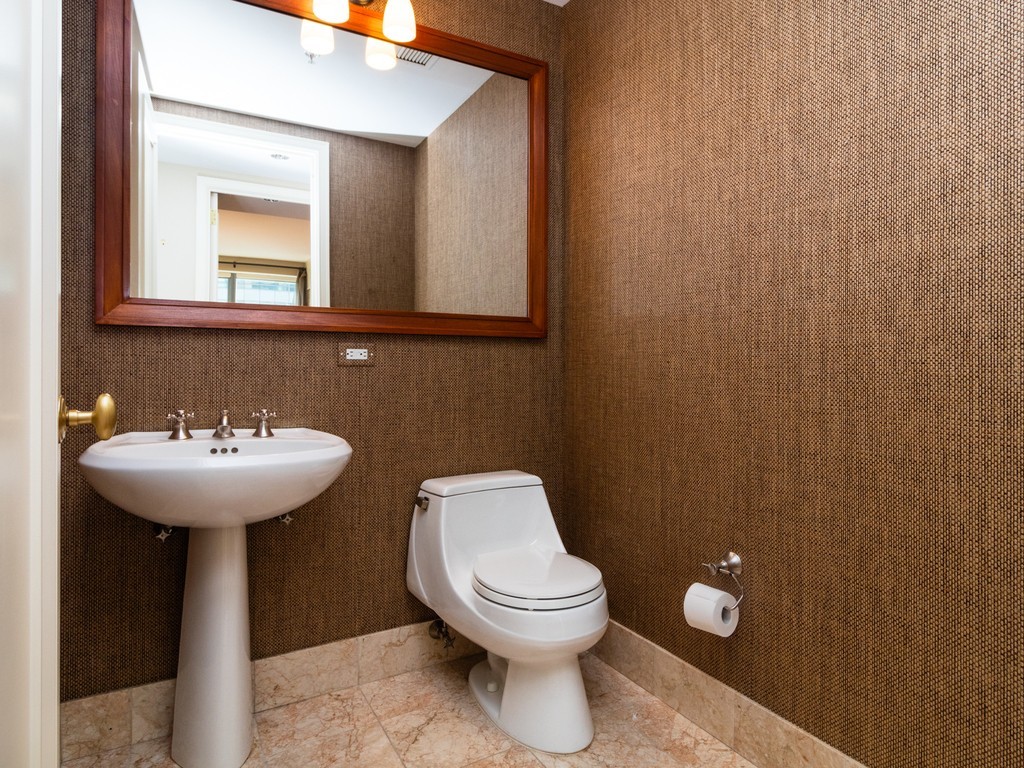 1 Avery Street, Unit 17C Boston, MA 02111 - Photo 6 of 10 a bathroom with a toilet a sink and mirror