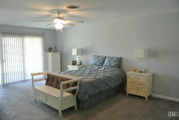 a spacious bedroom with a bed and a chandelier