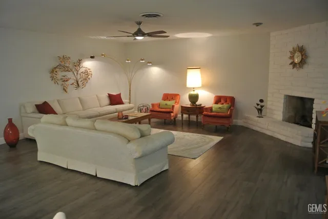 a living room with couches chairs and a fireplace with wooden floor