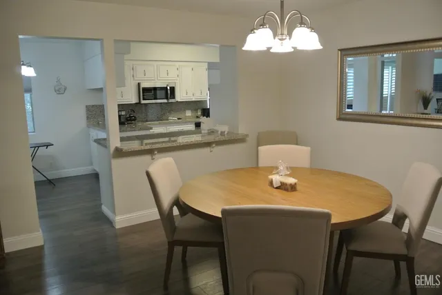 a dining room with a table chairs and kitchen view