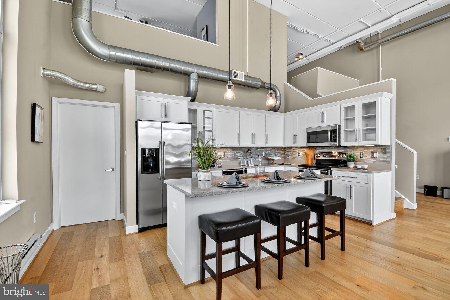 900 Bonifant Street, Unit D Silver Spring, MD 20910 - Photo 11 of 54 a kitchen with stainless steel appliances granite countertop a table chairs stove and white cabinets