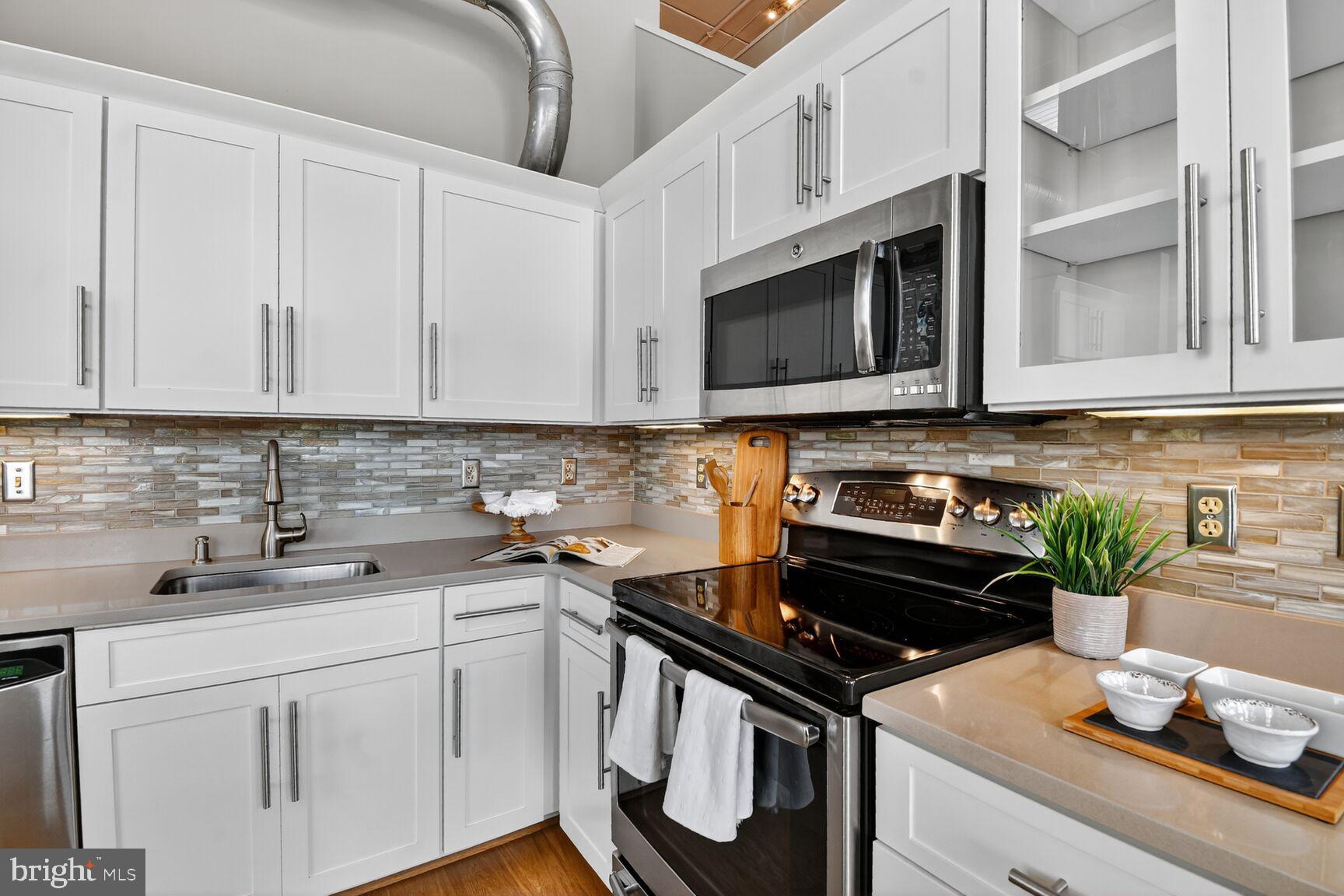 900 Bonifant Street, Unit D Silver Spring, MD 20910 - Photo 15 of 54 a kitchen with stainless steel appliances granite countertop a stove a microwave and cabinets