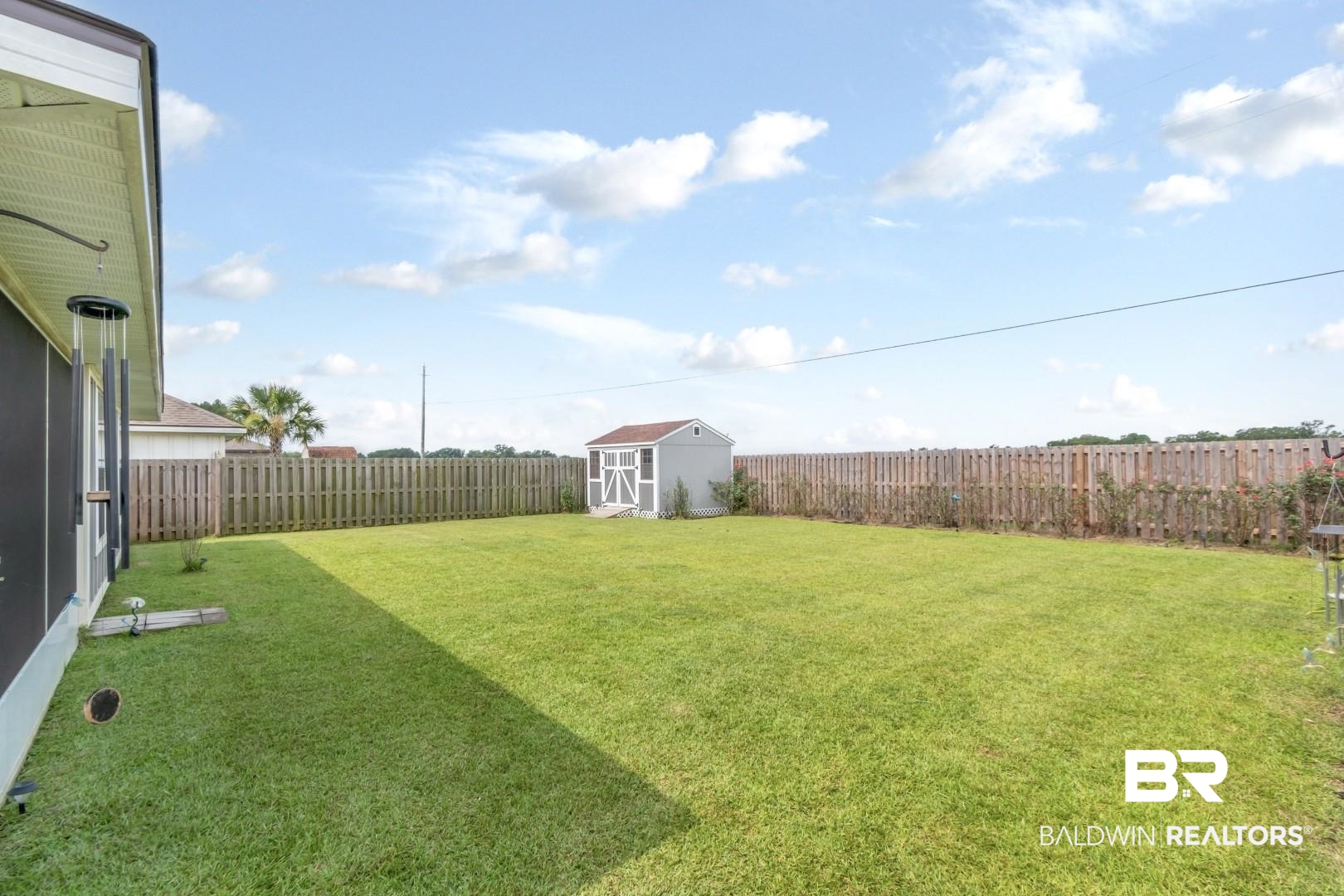 1295 Hayward Loop Foley, AL 36535 - Photo 24 of 29 Expansive backyard featuring a manicured lawn, full privacy fencing, and a dedicated storage shed