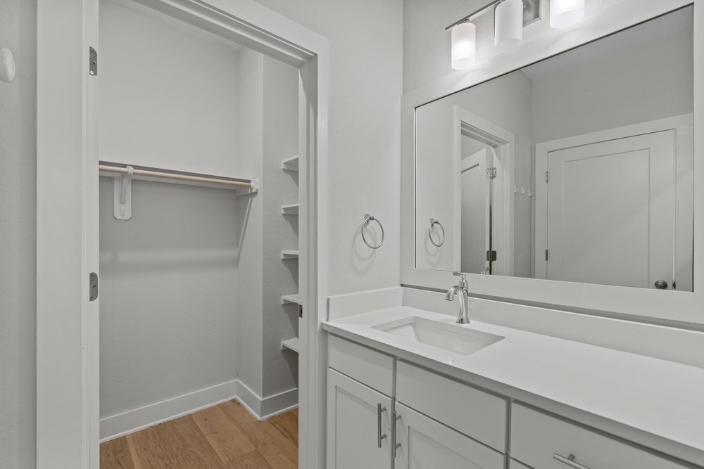 2827 Manor Road, Unit 2201 Austin, TX 78722 - Photo 37 of 40 Bathroom vanity with a rectangular undermount sink, a chrome faucet, and a large framed mirror with overhead lighting