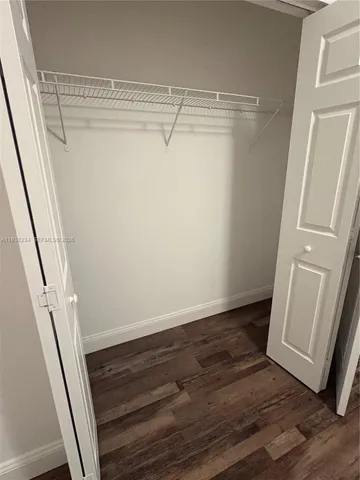 a view of storage and utility room with wooden floor