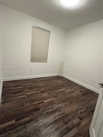a view of room with wooden floor and window
