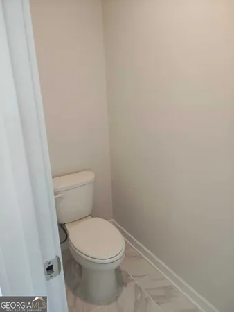 a white toilet sitting next to a shower