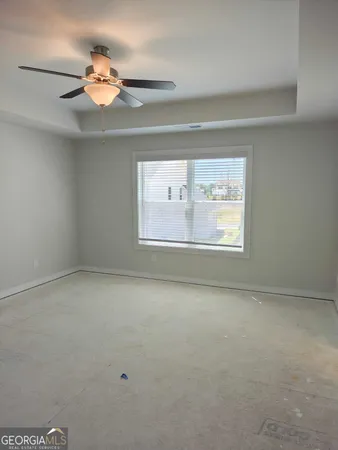en empty room with windows and chandelier fan