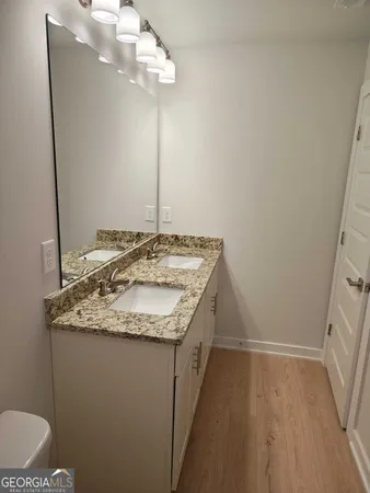 a bathroom with a granite countertop sink a toilet and a mirror