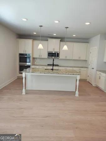 a large kitchen with kitchen island a stove a sink and a refrigerator