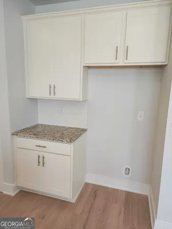 a view of a kitchen with white cabinets and a wooden floor