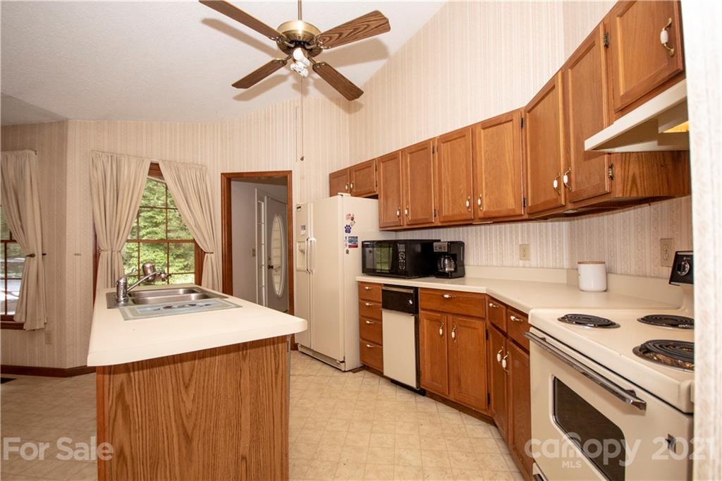 449 Oak Ridge Drive Clyde, NC 28721 - Photo 3 of 18 a kitchen with stainless steel appliances kitchen island a sink a stove and cabinets