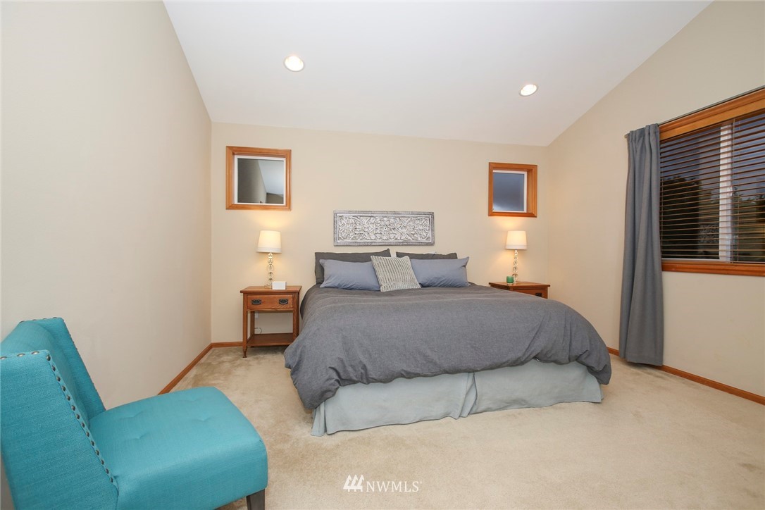 813 Field Avenue Northeast Renton, WA 98059 - Photo 18 of 22 a spacious bedroom with a bed a couch and a window