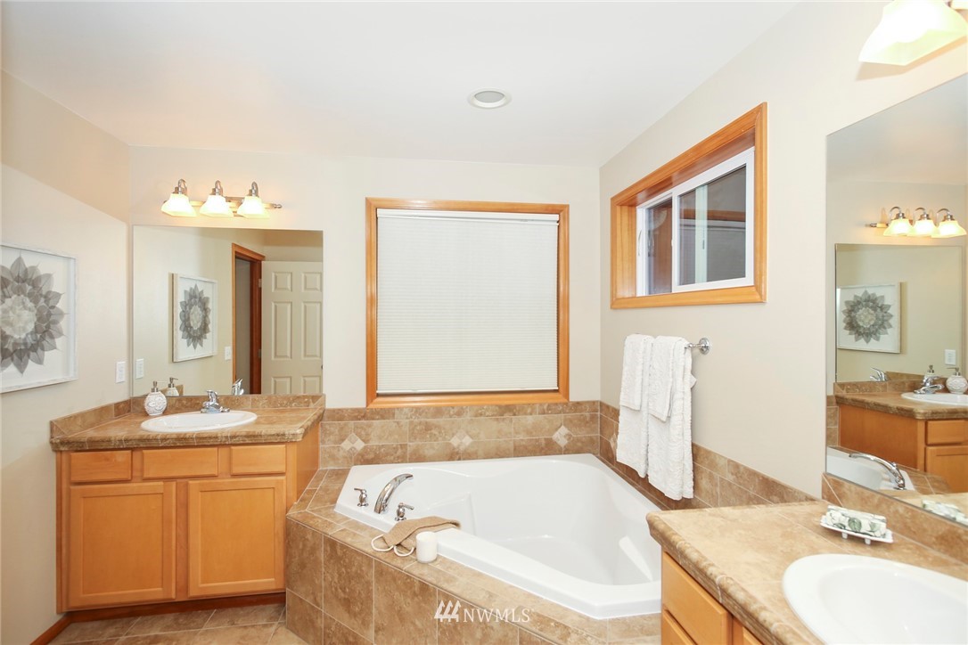 813 Field Avenue Northeast Renton, WA 98059 - Photo 19 of 22 a bathroom with a granite countertop tub sink and mirror