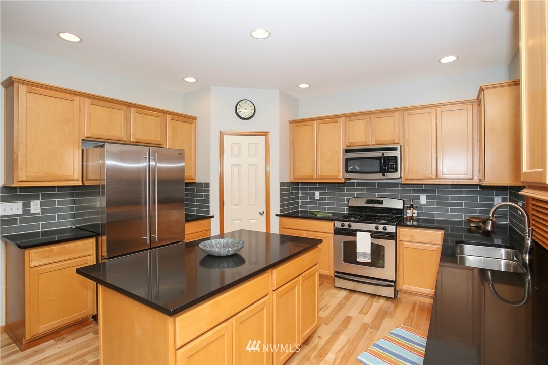 813 Field Avenue Northeast Renton, WA 98059 - Photo 8 of 22 a kitchen with stainless steel appliances granite countertop a sink a stove and a refrigerator